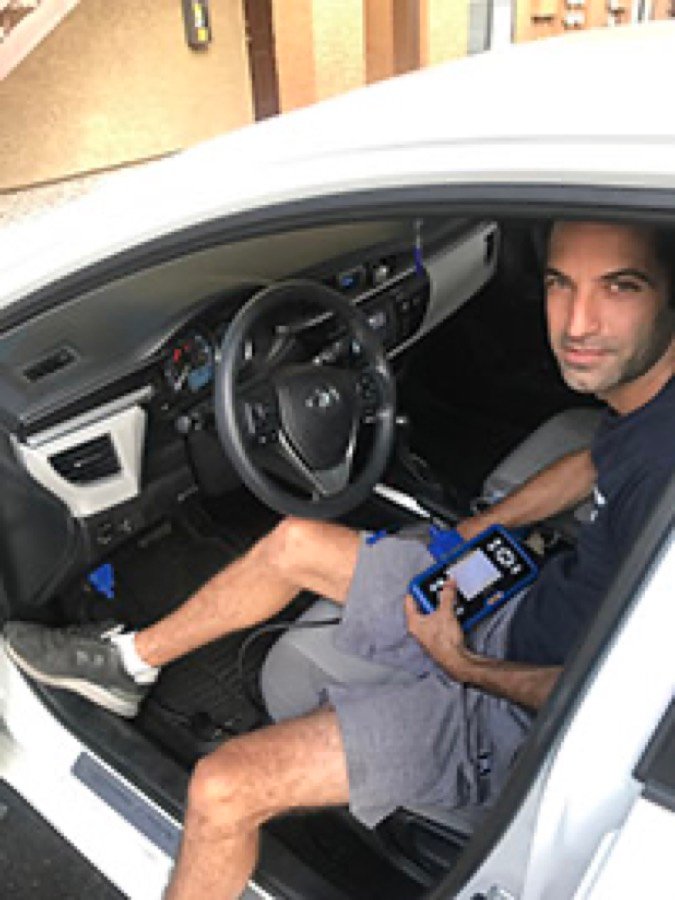 Area Locksmith technician programming a replacement Toyota key inside a Toyota Corolla in Las Vegas